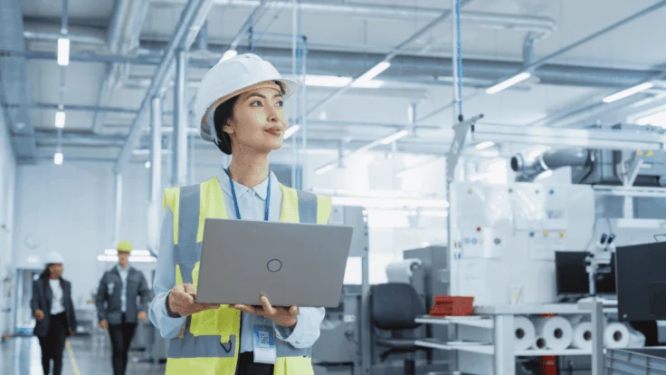 Ingenieurin mit Laptop in moderner Industriehalle als Beispiel für unterschätzte Fachberufe mit Zukunft 2026